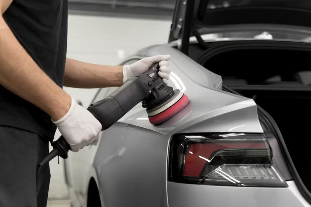 a close-up shot of a grey-coloured car being detailed by a man